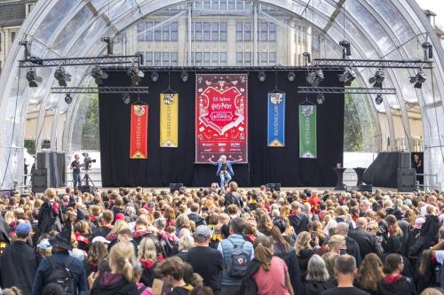 A crowd of people looking at a stage with Rufus Beck performing.